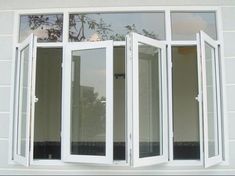 an open window on the side of a white building with double panes and windows