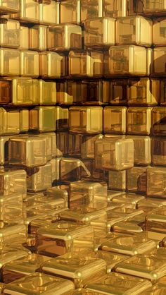 many gold bars are stacked on top of each other in an abstract pattern that resembles cubes