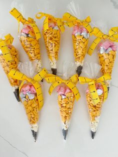 seven cones with measuring tape wrapped around them are arranged in the shape of corn on the cob