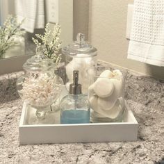 a bathroom counter with soap, lotion and other items on the tray in front of it