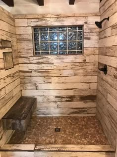 a rustic bathroom with wood planks and a bench in the corner, along with a glass block window