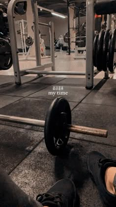 a person with their feet on the ground in front of a barbell