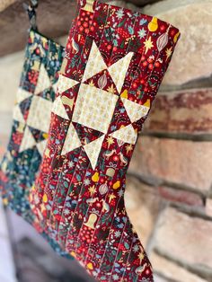 two christmas stockings hanging from a brick wall