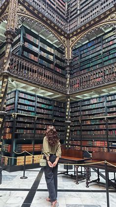 a woman standing in front of a library filled with lots of book shelves and bookshelves