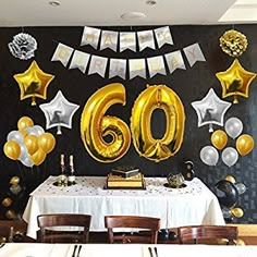 the table is set up with balloons and streamers for 60th birthday party decorating