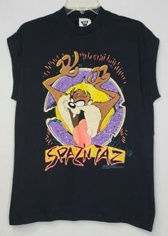 Vintage 1992 Spaz'n Taz Tasmanian Devil sleeveless shirt in adult size large.  Warner Bros. a Time Warner Entertainment Company. Made in USA There is a small tear on the right back shoulder.  Please see last picture. These are measurements for your guide:  Length - Neck to Hem:  27" Chest - Armpit to Armpit:  20" Vintage Tank T-shirt For Summer, Vintage Sleeveless T-shirt With Graphic Print, Vintage Sleeveless Tank Top With Graphic Print, Vintage Tank Top For Streetwear, 90s Style Sleeveless T-shirt For Streetwear, Vintage Graphic Muscle Tee For Summer, Vintage Graphic Print Muscle Tee For Summer, Vintage Sleeveless Graphic Print T-shirt, Vintage Summer Tank T-shirt