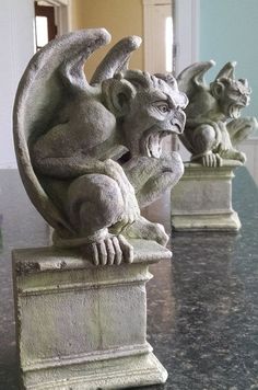 three gargoyle statues sitting on top of a marble table next to each other