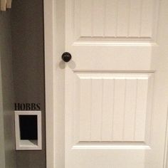 a white door with a black and white sign on the wall above it that says hobbs