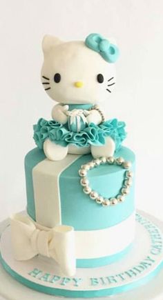 a hello kitty birthday cake with blue and white decorations