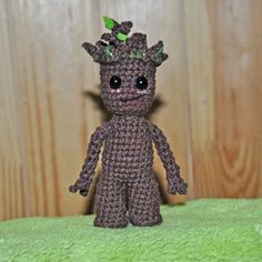 a small crocheted toy is sitting on a green blanket