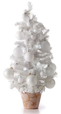 a white christmas tree in a pot with ornaments on it's top and bottom