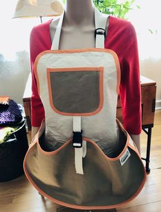 a mannequin with an orange and white backpack on it's back