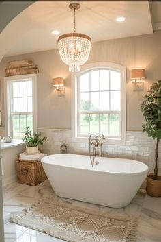 a bathroom with a large tub and chandelier hanging from it's ceiling