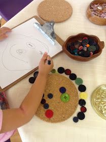 a child is drawing on a paper with buttons