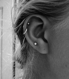 a woman's ear is shown with two piercings on the top and bottom