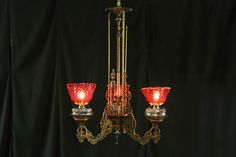 a chandelier with three red glass shades