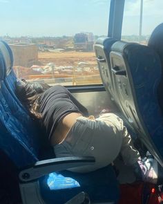 a person sleeping on an airplane seat with their head in the back and legs up