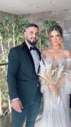 a man in a tuxedo standing next to a woman in a wedding dress