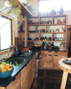 a kitchen filled with lots of wooden cabinets and counter top space next to a window