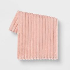 the rib knit scarf in pink is folded on top of a white surface and has an open