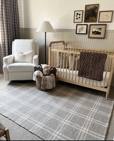 a baby crib in the middle of a room with pictures on the wall and an infant's bed next to it