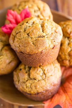 muffins stacked on top of each other in a bowl with autumn leaves around them