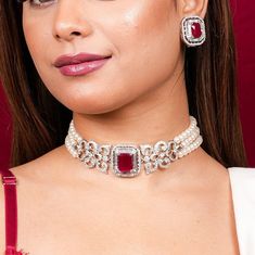 With this Manish Malhotra Jewelry Inspired, You can channel Princess Diana's iconic style with this Ruby Pearl Necklace. Wear a Ruby Choker Necklace to exude regality, or a Red Diamond Necklace to exude opulence. Choose a Pearl Diamond Choker for a touch of class. Inspired by Princess Diana's timeless style, these pieces combine the allure of rubies with the delicate beauty of pearls and diamonds, adding a touch of royal elegance to any ensemble. *𝐏𝐑𝐎𝐃𝐔𝐂𝐓 𝐃𝐄𝐓𝐀𝐈𝐋* * Material: Brass * Plating: White Rhodium Plated * Stone: AAA-quality CZ diamond & Ruby. *𝐃𝐈𝐌𝐄𝐍𝐒𝐈𝐎𝐍𝐒*  Necklace * Weight: 55 gm * Width: 1.15 Inches * Design Length: 10 inches * Total Length with Closure: 14.2 inches  Earrings * Weight: 9 gm each * Length: 1 Inch * Width:  0.9 Inches * Closure: Push Back *? Ruby Diamond Choker, Choker Diamond Necklace, Diamond Ruby Necklace, Red Ruby Necklace, Ruby Choker, Ruby Red Necklace, Ruby Necklace Designs, Ruby And Pearl, Ruby Diamond Necklace