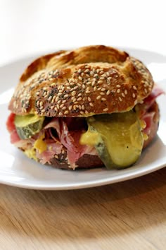 a close up of a sandwich on a plate with sesame seeds and other toppings