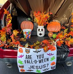 the trunk of a car decorated for halloween with pumpkins, leaves and other decorations