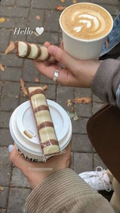 a person holding a cup of coffee and some food