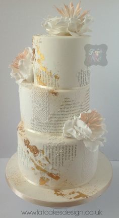 a three tiered wedding cake with flowers on top