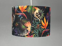 a lamp shade with birds and flowers on it