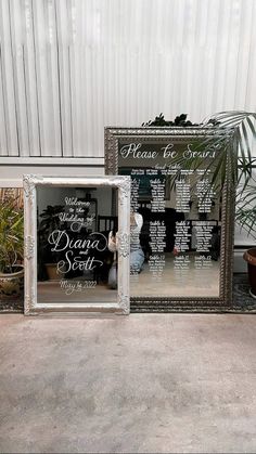 a mirror frame sitting on top of a floor next to a potted palm tree