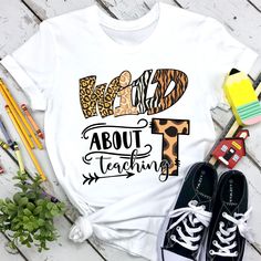 a white shirt with leopard print and the words wild about grace on it next to some shoes