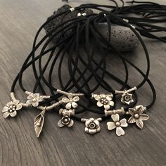 Unique one of a kind silver flower charms choker. 10 different necklaces, made with a long black leather cord and 10 unique silver flower pendants with silver beads. This necklaces can be adjusted to chokers or can be long necklaces like you can see in the picture. Perfect stacking necklaces that will rock your outfit and will be easy to match other accessories. You can see in 2 of the pictures that each flower choker has a number, that way you know which one are choosing. A unique addition to y Adjustable Flower Charm Pendant Necklace, Handmade Adjustable Charm Necklace Choker, Handmade Adjustable Choker Charm Necklace, Handmade Adjustable Charm Choker Necklace, Adjustable Handmade Charm Necklace Choker, Handmade Adjustable Charm Necklace, Adjustable Flower Charm Festival Jewelry, Adjustable Flower Charm Necklace With Flower Pendant, Adjustable Silver Flower Charm Necklaces