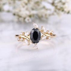 a black and white ring sitting on top of a table next to some flower petals