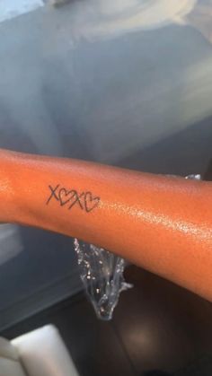 a person's arm with the word xoxo tattooed on it