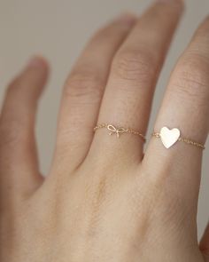 This 14k gold chain ring features a delicate bow, making it ideal for everyday wear. Its petite design is perfect for making a subtle statement. * 14k Yellow Gold * Bow measures approx. 6mm    * Same Style Necklace: https://www.etsy.com/listing/1611306083/14k-gold-dainty-bow-necklace-tiny-bow?click_key=9dd688161579bb004abb4ef357dff8734744d24e%3A1611306083&click_sum=7aed8dbc&ref=shop_home_active_3&frs=1&sts=1 ■ SHIPPING UPGRADES You can find shipping upgrades options in the drop bar menu when you check out. * Within the U.S Regular First-class : 2-6 business days Priority : 2-3days Express : 1-2 days * International International Priority : 6-10 Business days Rush International Express : 3-6 business days * Our current processing time is 2-7 business days. Please note that shipping times do Minimalist Gold Jewelry With Bow, Delicate Rings With Delicate Chain As Gift, Delicate Chain Rings As Gift, Elegant Rings With Delicate Chain For Gift, Gold Chain Ring, Cute Ring, Mini Bow, Tiny Bow, Bow Ring