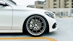 a white car parked in front of a building on a parking lot with yellow lines