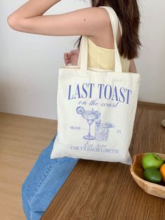 a woman sitting on the floor with a tote bag in front of her, next to some fruit