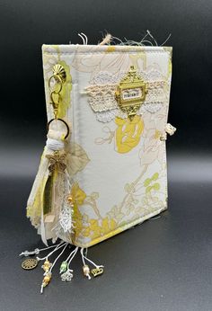 an open book with keychains and tags attached to the cover, sitting on a table