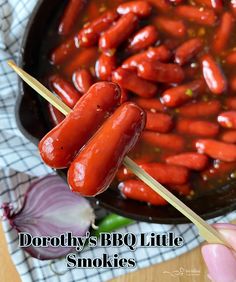 two hotdogs on skewers being dipped with toothpicks in a bowl