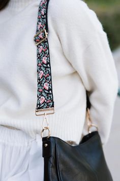 Add a touch of excitement to your wardrobe with our Botanical Bliss Strap. Made from a soft, woven like material, this strap features exquisite orange flowers and delicate teal leaves that are beautifully stitched. This adds a unique and stylish touch to any bag. This strap is paired with the Marcella Bag in the photos. Botanical Strap Details: Adjusts from 32" - 58" in length 2" wide Gold hardware Polyester material. Woven feel, thicker strap Adjustable Bag Strap, Western Graphic Tees, Adjustable Bag, Convertible Bags, Quiet Luxury, Saddle Bag, Jewelry Case, Watch Necklace, Orange Flowers