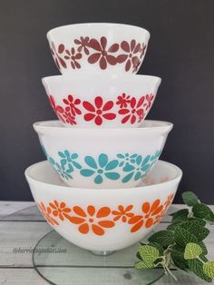 four bowls stacked on top of each other with flowers painted on the bottom and sides