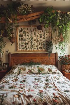 a bed covered in lots of green plants next to a wall hanging above it's headboard