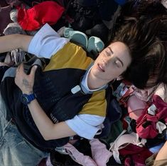 a woman laying on top of a pile of clothes