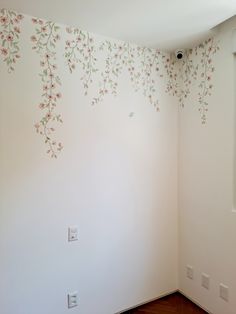 an empty room with painted flowers on the wall