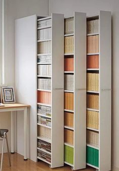 a room divider with several bookshelves in it and a table next to it