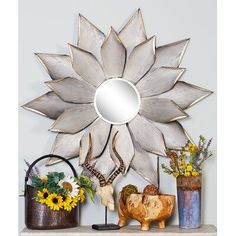 a decorative mirror on top of a mantle next to vases with flowers in them