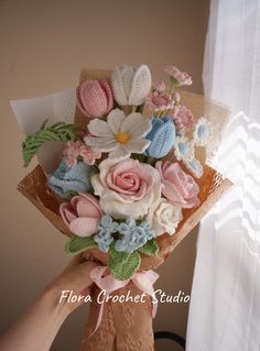 a person holding a bouquet of flowers in front of a window